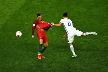 Cristiano Ronaldo sujetado por Mauricio Isla de Chile durante la semifinal de la Copa Confederaciones en Rusia