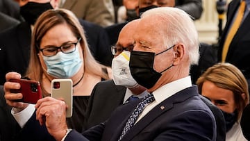 President Joe Biden takes a selfie during an event honoring labor unions in the East Room at the White House in Washington.