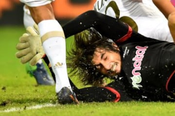 El portero del Genoa, Mattia Perin despeja el balón ante Carlos Bacca del Milan.