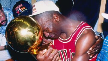 Michael Jordan abraza el trofeo que le acreditaba como campeón de las Finales de 1991 frente a los Lakers. En la instantánea se puede ver al escolta emocionado agarrado el trofeo y abrazado por su padre y su esposa. Estas finales de la NBA serían las primeras que disputaria el mejor jugador de todos los tiempos del baloncesto.