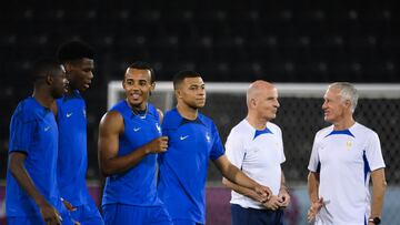 France's coach Didier Deschamps (R) and France's assistant coach Guy Stephan (2nd R) speak together as (from L) France's forward Ousmane Dembele, France's midfielder Aurelien Tchouameni, France's defender Jules Kounde and France's forward Kylian Mbappe walk past them during a training session at the Al Sadd SC training center in Doha, on December 3, 2022, on the eve of the Qatar 2022 World Cup round of 16 football match between France and Poland. (Photo by FRANCK FIFE / AFP)