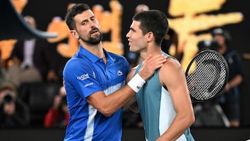 Serbia's Novak Djokovic (L) embraces Spain's Carlos Alcaraz after their men's singles quarterfinal match on day ten of the Australian Open tennis tournament in Melbourne on January 22, 2025. (Photo by WILLIAM WEST / AFP) / -- IMAGE RESTRICTED TO EDITORIAL USE - STRICTLY NO COMMERCIAL USE --