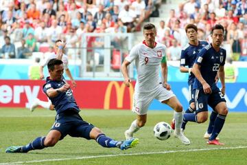 Playing it safe | Tomoaki Makino of Japan clears the ball under pressure from Robert Lewandowski of Poland during the 2018 FIFA World Cup.