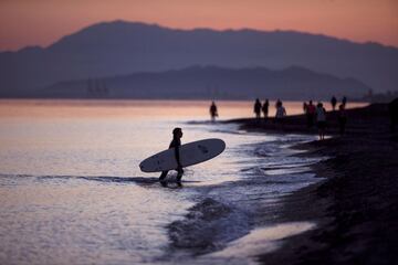 Un hombre practica surf a última hora de la tarde de este sábado, en la playa de Torre de Benagalbón en el Rincón de la Victoria (Málaga), dentro de la nueva normativa que permite hacer actividades deportivas y pasear en dos franjas horarias, cuando se cumple 48 días de confinamiento en el estado de alarma decretado por el Gobierno por la crisis de la COVID-19. 