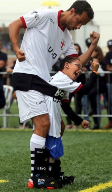 El futbolista brasileño Nene y el niño Rikellmy celebran un gol durante  un evento con niños discapacitados en Praia Grande (Brasil).