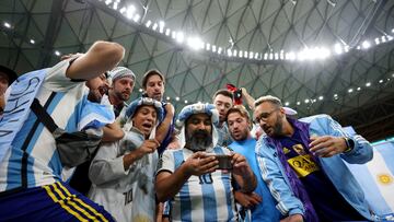  Los hinchas argentinos estuvieron muy pendientes de todo lo que ocurría en el Education City entre Croacia y Brasil. Como este grupo de aficionados albicelestes, quienes siguen a través de un teléfono móvil, en las gradas del estadio de Lusail, la tanda de penaltis entre ambas selecciones antes del comienzo del Países Bajos-Argentina. 