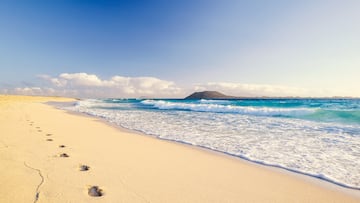 Stunning morning view of the islands of Lobos and Lanzarote seen from Corralejo Beach (Grandes Playas de Corralejo) on Fuerteventura, Canary Islands, Spain, Europe. Beautiful footprints in the sand.