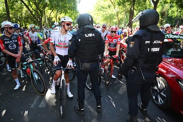 Ivo Oliveira habla con la policía con el pelotón parado detrás en la última etapa de La Vuelta. 