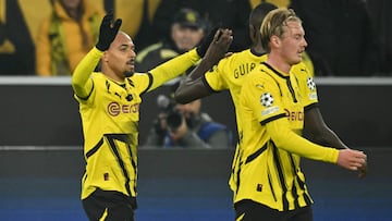 Dortmund's Dutch forward #21 Donyell Malen celebrates scoring the opening goal with his teammates Dortmund's Guinean forward #09 Serhou Guirassy and Dortmund's German midfielder #10 Julian Brandt during the UEFA Champions League football match BVB Borussia Dortmund vs SK Sturm Graz in Dortmund, western Germany on November 5, 2024. (Photo by INA FASSBENDER / AFP)