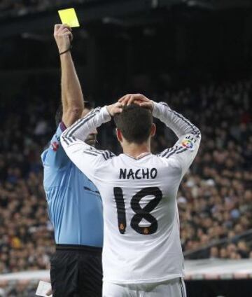 El colegiado Fernando Teixeira Vitienes muestra la cartulina amarilla a Nacho.