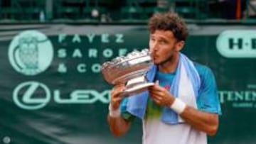 Juan Mónaco besa el trofeo de campeón del Torneo de Houston después de vencer en la final al estadounidense Jack Sock.