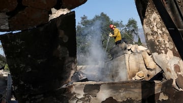 A firefighter extinguishes hot spots in a burned out structure, in the area affected by devastating Eaton Fire in Altadena, California, U.S. January 10, 2025. REUTERS/Mario Anzuoni TPX IMAGES OF THE DAY