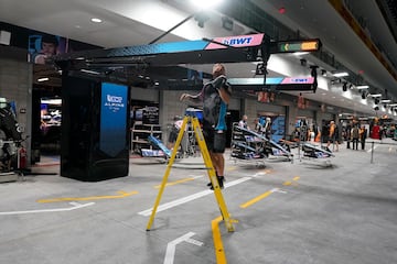 Un miembro del equipo del piloto de Alpine, Esteban Ocon, de Francia, limpia el box antes de la primera sesión de práctica.