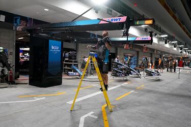 Un miembro del equipo del piloto de Alpine, Esteban Ocon, de Francia, limpia el box antes de la primera sesión de práctica.