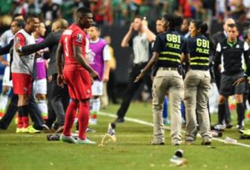Members of the Georgia Bureau of Investigations (GBI) police intervene as scuffles break out between members of Panama's and Mexico's national teams after the referee awarded Mexico a controversial penalty during g a CONCACAF Gold Cup semifinal football match in Atlanta on July 22, 2015. Fans also threw drinks and other objects onto the field. AFP PHOTO/NICHOLAS KAMM