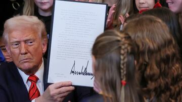 U.S. President Donald Trump holds up a signed executive order banning transgender girls and women from participating in women's sports, in the East Room at the White House in Washington, U.S., February 5, 2025. REUTERS/Leah Millis