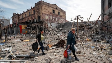 FILE PHOTO: Residents carry their belongings near buildings destroyed in the course of Ukraine-Russia conflict, in the southern port city of Mariupol, Ukraine April 10, 2022. REUTERS/Alexander Ermochenko/File Photo NO RESALES. NO ARCHIVES