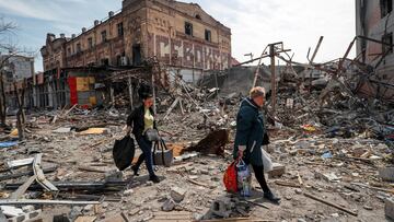 FILE PHOTO: Residents carry their belongings near buildings destroyed in the course of Ukraine-Russia conflict, in the southern port city of Mariupol, Ukraine April 10, 2022. REUTERS/Alexander Ermochenko/File Photo  NO RESALES. NO ARCHIVES