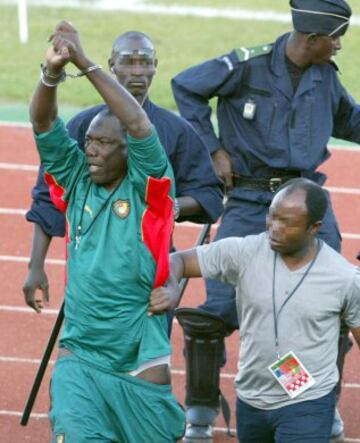 Thomas N'Kono, asistente de entrenador alemán de Camerún Winfried Schaefer levanta las manos esposadas después de ser detenido por una docena de policías malienses, acusado de haber lanzado un (objeto mágico) gri-gri al terreno de juego.