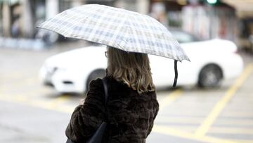 Archivo - Persona con paraguas por la lluvia