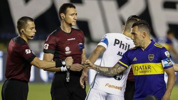 Argentina's Boca Juniors Carlos Tevez (R) greets the referees before the start of the Copa Libertadores semifinal football match against Brazil's Santos at the Vila Belmiro stadium in Santos, Brazil, on January 13, 2021. (Photo by Sebastiao Moreira / POOL / AFP)