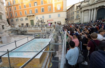 Los visitantes tiran monedas a la nueva bañera instalada por el ayuntamiento de Roma.