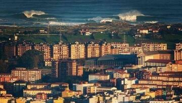 La ciudad de Santander (Cantabria) con la ola gigante de La Vaca rompiendo al fondo. 