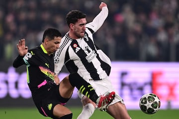 Juventus' Serbian forward #09 Dusan Vlahovic fights for the ball with PSV Eindhoven's Brazilian defender #17 Mauro Junior during the UEFA Champions League knockout phase play-off 1st leg football match between Juventus and PSV Eindhoven at the Allianz stadium in Turin, on February 11, 2025. (Photo by Marco BERTORELLO / AFP)