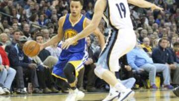 Stephen Curry conduce el balón ante la presión de Beno Udrih.