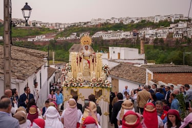 Penitentes de la hermandad "La Borriquita" llevan una plataforma portátil que sostiene una estatua de la Virgen "María Santísima del Amor y la Paz, Madre Protectora de la Infancia de Montoro" durante una procesión de Semana Santa en Montoro, Córdoba, España. 


