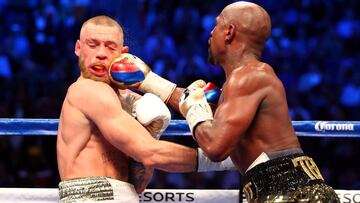 Floyd Mayweather Jr. golpea a Conor McGregor durante su combate de boxeo el 26 de agosto de 2017.
