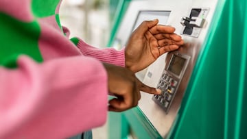 Unrecognizable young adult african woman hand entering personal identification number on ATM dial panel - Millennial person withdrawing money at automatic ATM machine typing secret security code number