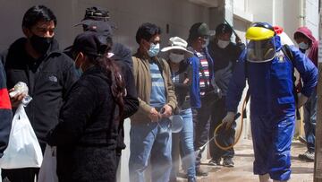 A health worker sprays disinfectant against the spread of Covid-19 in the streets of the Andean city of Puno, Peru, close to the border with Bolivia, on April 19, 2021. - Peru registered this Sunday for the first time more than 400 deaths from covid-19 in 24 hours, amid a sharp increase in infections driven by the Brazilian variant of the virus spread throughout the country, reported the Ministry of Health. (Photo by Juan Carlos CISNEROS / AFP)