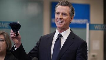 ARCHIVO - En esta foto de archivo del 26 de julio de 2021, el gobernador Gavin Newsom sostiene una mascarilla mientras habla en una conferencia de prensa en Oakland, California. 