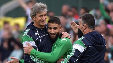 Real Betis' French midfielder Nabil Fekir (C) celebrates with Real Betis' Chilean coach Manuel Pellegrini at the end of the Spanish league football match between Real Betis and Athletic Club Bilbao at the Benito Villamarin stadium in Seville on March 13, 2022. (Photo by CRISTINA QUICLER / AFP)