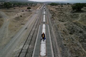 Migrantes, en su mayoría venezolanos, caminan encima de vagones de ferrocarril mientras se preparan para continuar su viaje hacia la frontera con Estados Unidos.