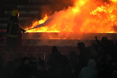 Un bombero extingue asientos en llamas durante un derbi de la liga nacional de fútbol de Serbia entre el Estrella Roja y el Partizán.