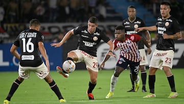 Universitario's defender Aldo Corzo (2nd L) and Junior's forward Deiber Caicedo (3rd L) fight for the ball during the Copa Libertadores group stage first leg football match between Colombia's Junior and Peru's Universitario at the Metropolitano Roberto Melendez Stadium in Barranquilla, Colombia, on April 9, 2024. (Photo by Luis ACOSTA / AFP)