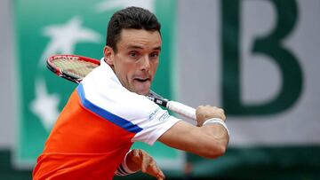 Roberto Bautista Agut devuelve una bola a Novak Djokovic durante su partido en Roland Garros.