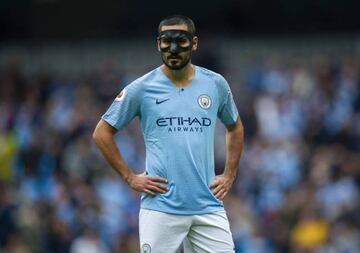 Manchester City's Ilkay Gundogan wears a protective face mask during the English Premier League soccer match between Manchester City and Huddersfield Town at the Etihad Stadium