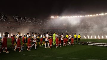 Players of Boca Juniors (blue and yellow) and River Plate (red stripe) step onto the field before the start of their all-Argentine Copa Libertadores semi-final first leg football match at the Monumental stadium in Buenos Aires, on October 1, 2019. (Photo by Alejandro PAGNI / AFP)