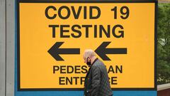 A pedestrian walks past a sign directing members of the public to a Covid-19 testing centre in Bolton, northwest England, on May 28, 2021. - British Prime Minister Boris Johnson said Wednesday that Covid-19 vaccines are proving effective against a variant