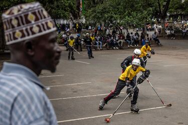 Miembros del equipo nacional de hockey sobre hielo de Kenia practican con patines en línea, mientras enseñan el juego a jóvenes que no pueden permitirse acudir a una pista de hielo, en un aparcamiento en el centro de Nairobi. El hockey sobre hielo llegó a Kenia en 2006, cuando un grupo de canadienses instalaron en su capital la única pista de África Oriental.