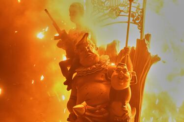 Un ninot que representa al presidente estadounidense Donald Trump, al presidente ruso Vladimir Putin y al líder norcoreano Kim Jong-un, comienzan a arder durante las Fallas en Valencia.