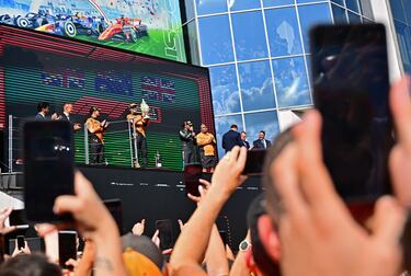 Aficionados toman fotos con sus móviles buscando encontrar una buena foto de la celebración de Oscar Piastri en el podio tras ganar el GP de Hungría.