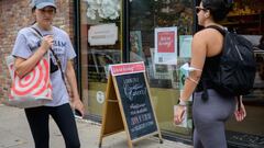 In this file photo taken on August 20, 2021 People walk past a &#039;We&#039;re hiring!&#039; sign posted at a store in New York City. 