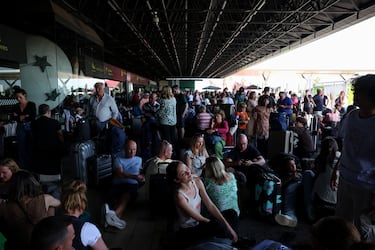 Personas esperan fuera de una terminal del Aeropuerto de Lisboa durante un corte de energía, en Lisboa.