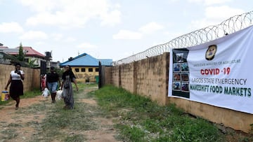 Women walk away from a temporary makeshift food market established by Lagos State government for residents of the Ilupeju community in Lagos on April 3, 2020. - The Nigerian government has approved the establishment of temporary makeshift food markets in