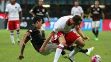 El jugador del AC Milán Carlos Bacca disputa el balón con Massimo Volta del AC Perugia.