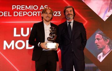 Luka Modric, jugador del Real Madrid, posa con el trofeo tras recibir de manos de Bernabé Mohedano, director de medios y marketing digital del Grupo Santander.